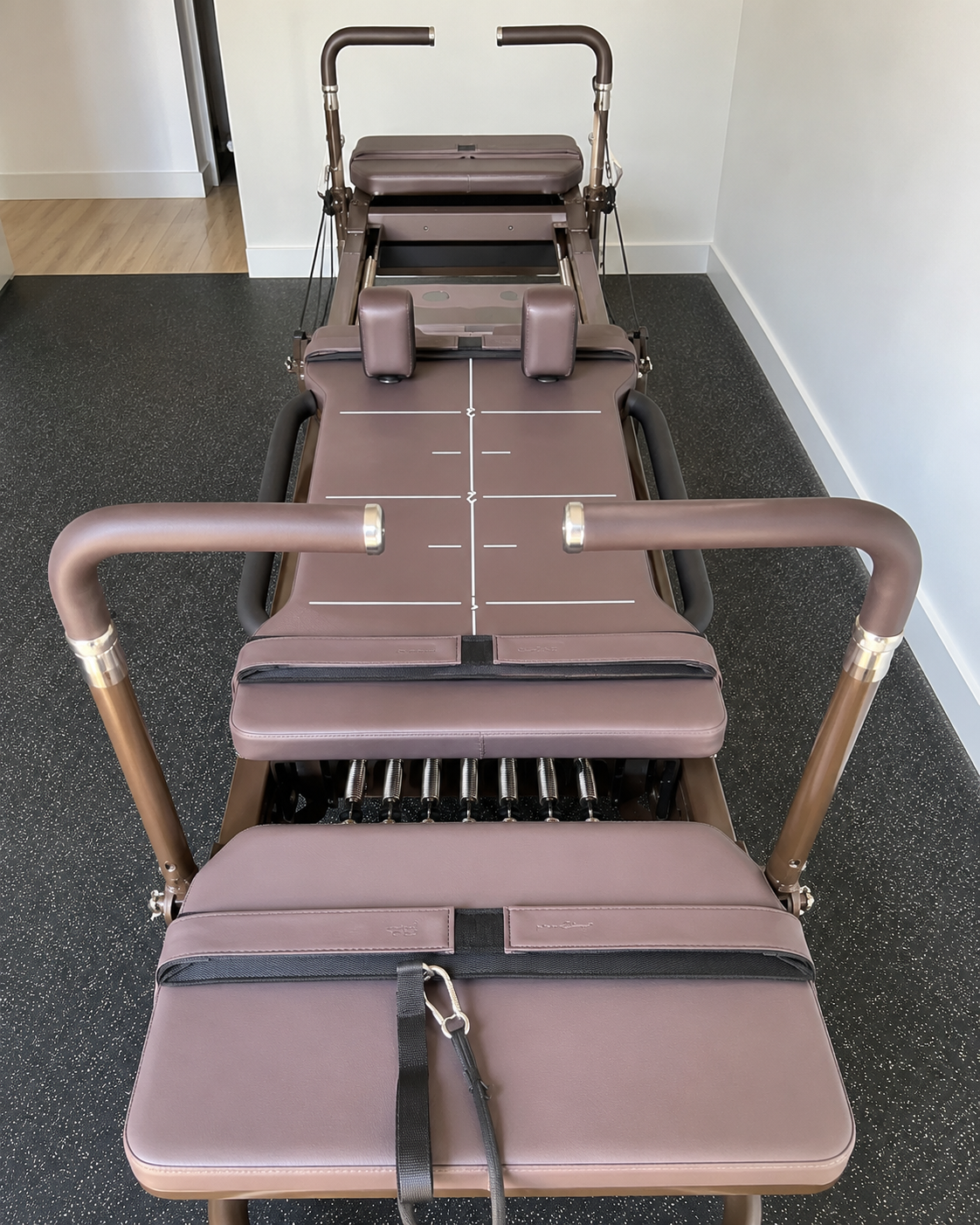 The Park Anywhere burgundy and bronze-olive reformer-style machine